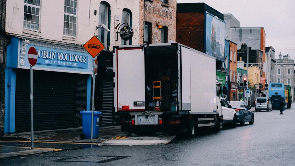 A busy street scene in Dublin's Temple Bar district showing pedestrians walking along the pavement and crossing the road, with a variety of shops and restaurants on both sides. Storefronts display sig